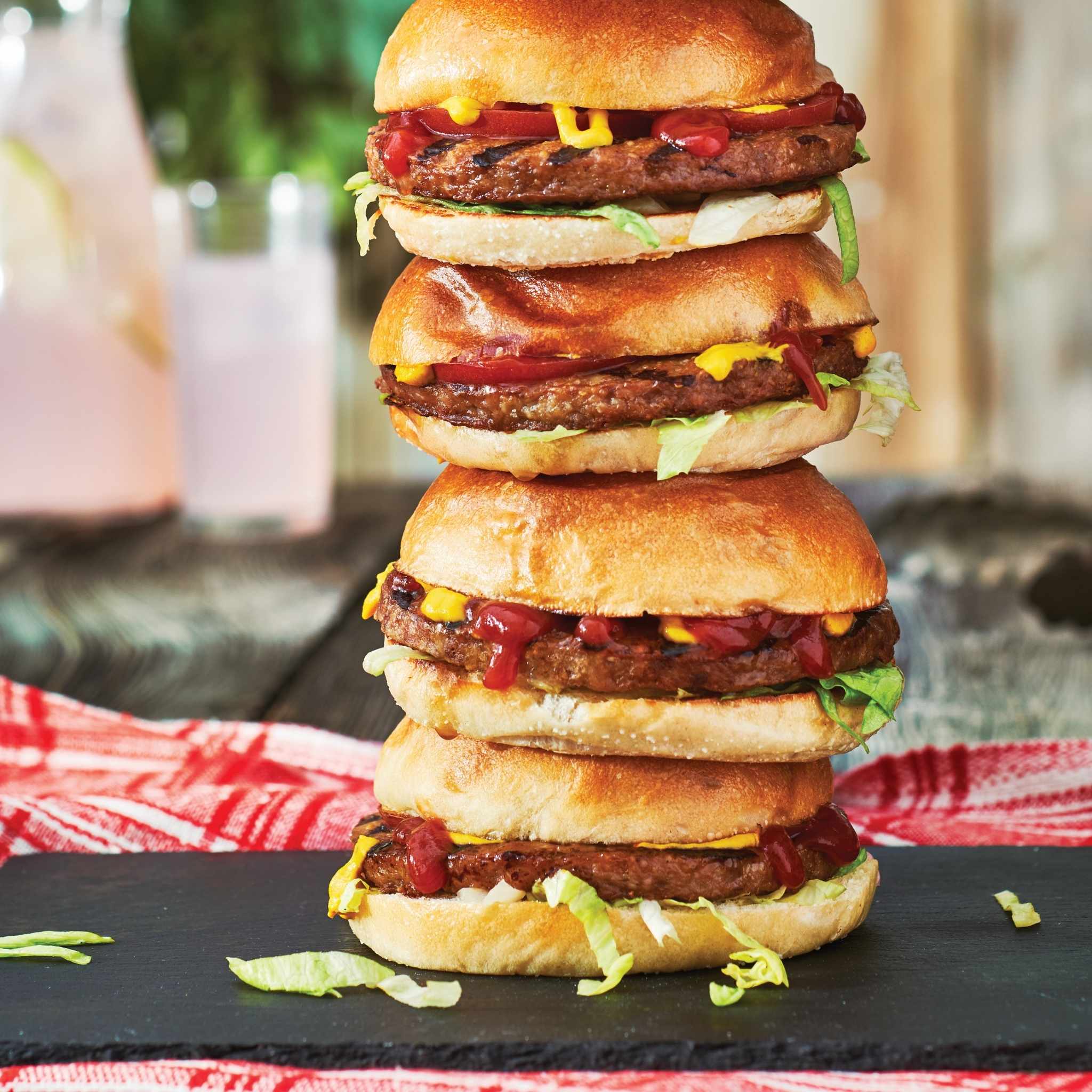 Pile de quatre burgers savoureux sur une surface en ardoise noire
