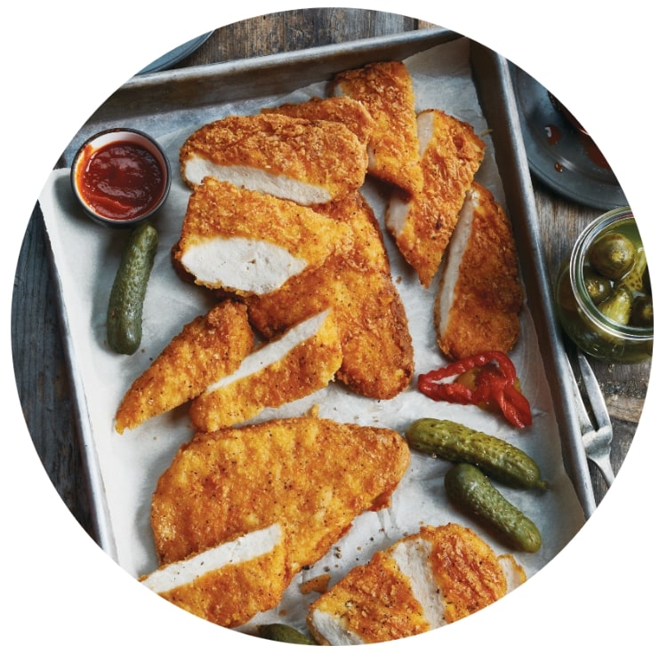 Poitrines de poulet épicées sur un plateau avec cornichons